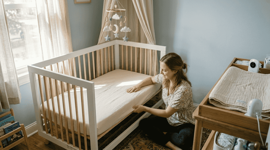 Mother preparing safe, pillow-free nursery crib
