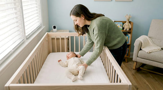 Parent placing baby in bare crib safely