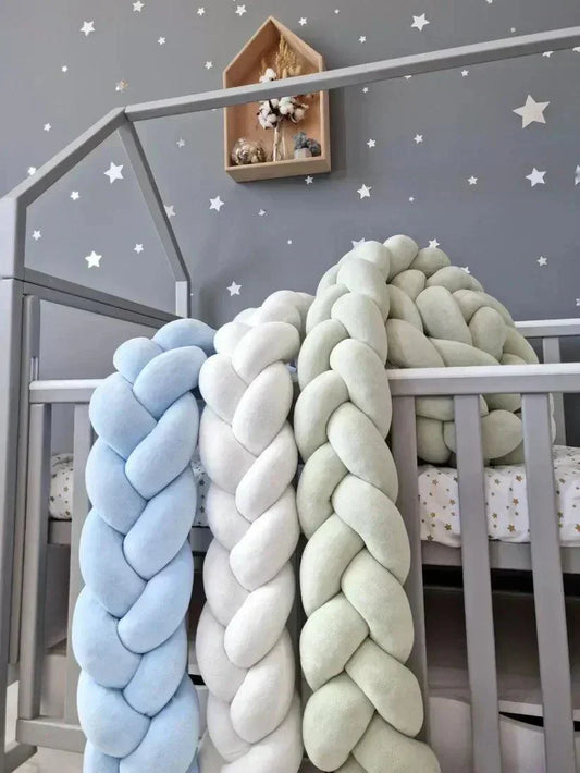 Colorful braided crib bumper in baby nursery showing different materials and designs for safe baby sleep