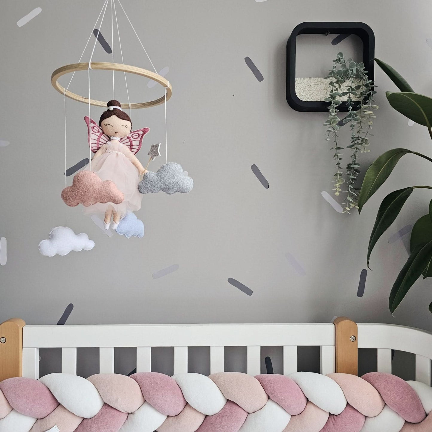 Children's room with a crib, mobile, and wall decorations.