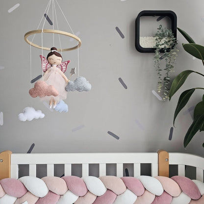 Children's room with a crib, mobile, and wall decorations.