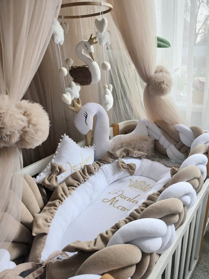 Baby crib with swan-themed decorations and canopy
