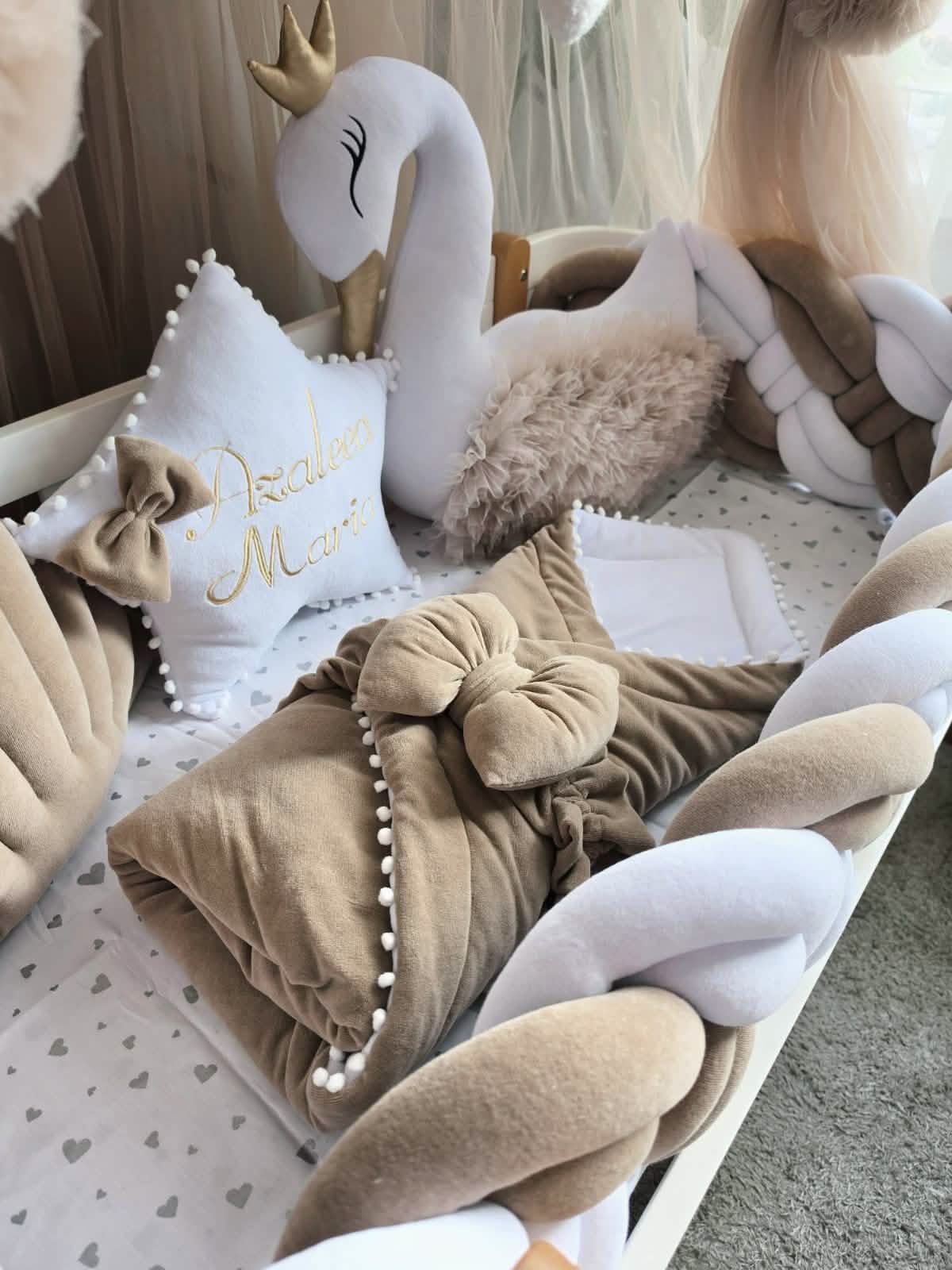 Collection of decorative pillows with a swan plush toy in the background