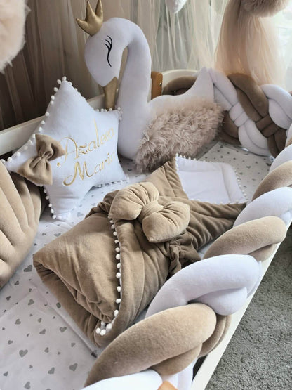Collection of decorative pillows with a swan plush toy in the background
